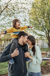 Playful family enjoying in front yard - ANAF01435