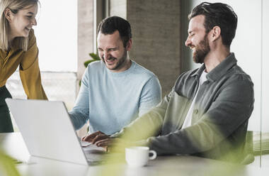 Glückliche Geschäftskollegen lachen im Büro - UUF28572