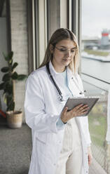 Young female doctor holding tablet PC at hospital - UUF28598