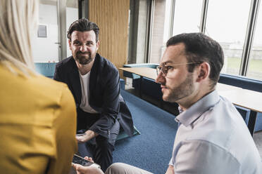 Geschäftsmann macht Gesicht bei einem Treffen mit Kollegen im Büro - UUF28651