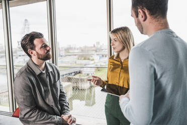 Junge Geschäftsfrau erklärt Kollegen bei einem Treffen im Büro - UUF28653