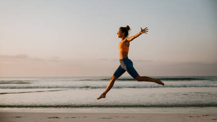 Young excited woman running and jumping at the beach, morning routine and healthy lifestyle concept. - HPIF09671