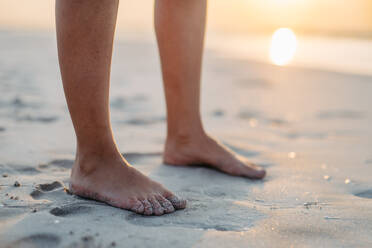 Nahaufnahme von Frauenfüßen im Sand, am Meer. - HPIF09672