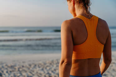 Rückansicht einer jungen, sportlichen Frau am Strand. - HPIF09680