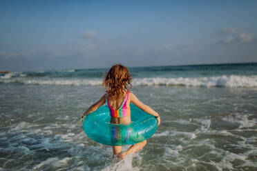 Rückansicht eines kleinen Mädchens, das das Meer genießt. - HPIF09695