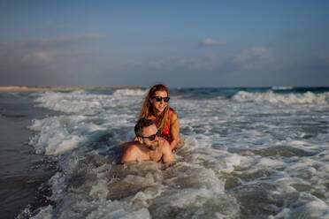 Happy couple in water, enjoying ocean together. - HPIF09701