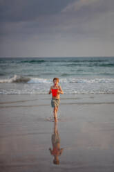 Kleiner Junge im Badeanzug läuft aus dem Meer und genießt den Sommerurlaub. - HPIF09714