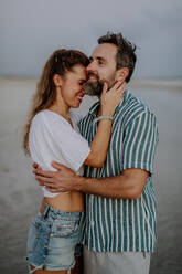 Porträt eines glücklichen Paares, das sich umarmt und den Urlaub am Meer genießt. - HPIF09751
