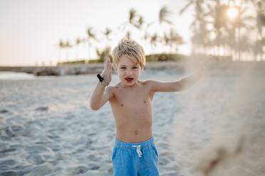 Kleiner verspielter Junge spielt mit Sand am Strand. - HPIF09803