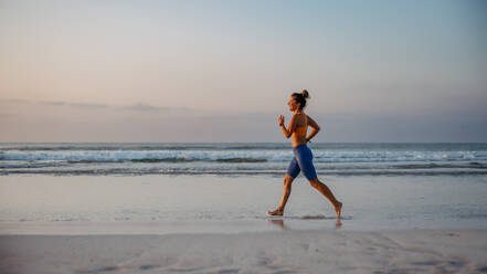Junge Frau läuft am Strand, Morgenroutine und gesunder Lebensstil Konzept. - HPIF09826