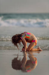 Kleines Mädchen sucht am Strand nach Muscheln und genießt den exotischen Urlaub. - HPIF09842