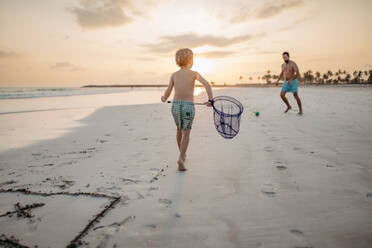 Vater mit seinem Sohn beim Fußballspielen am Strand. - HPIF09846