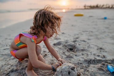Kleines Mädchen spielt am Strand und baut eine Sandburg. - HPIF09847