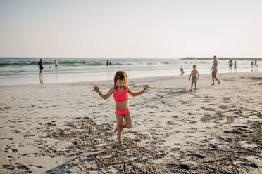 Kleines Mädchen springt am Strand während des Sommerurlaubs. - HPIF09858