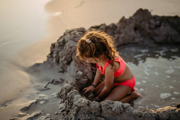 Kleines Mädchen spielt am Strand und gräbt ein Loch in den Sand. - HPIF09861
