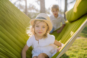 Little siblings enjoying their holiday in exotic country, lying in hammock. - HPIF09871