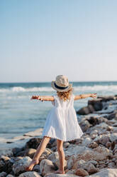 Rear view of little girl looking at the ocean. - HPIF09874