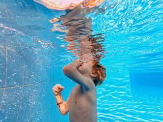 Kleiner Junge im Badeanzug beim Tauchen in einem Schwimmbad. - HPIF09885