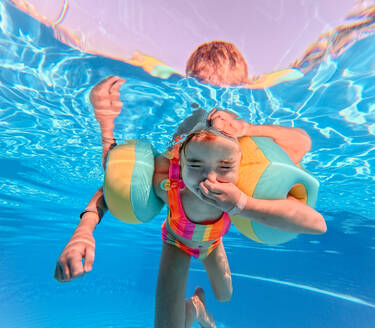 Kleines Mädchen im Badeanzug beim Tauchen in einem Schwimmbad. - HPIF09887