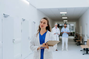 Portrait of young woman doctor at a hospital corridor. - HPIF09904