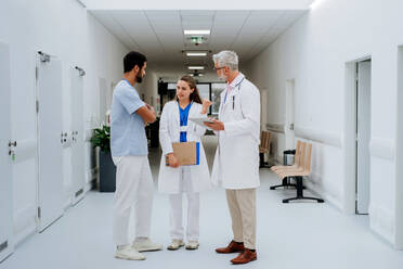 Ein Ärzteteam bespricht etwas in einem Krankenhausflur. - HPIF09910
