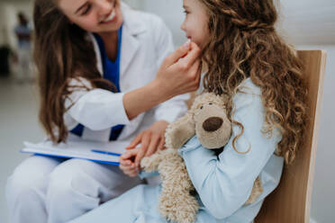 Junger Arzt spielt mit seinem kleinen Patienten auf dem Flur der Kinderklinik. - HPIF09924