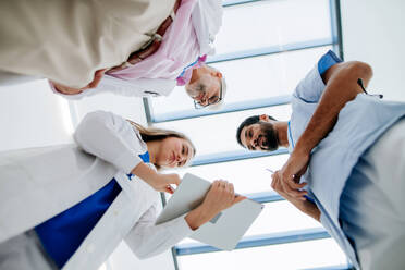 Team of doctors meeting at a hospital corridor, low angle view. - HPIF09930