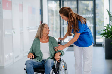 Young woman doctor taking care of senior woman at a wheelchair. - HPIF09965