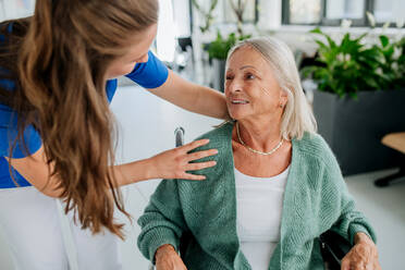 Young woman doctor taking care of senior woman at a wheelchair. - HPIF09967