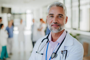 Porträt eines reifen Arztes in einem Krankenhauskorridor. - HPIF09991