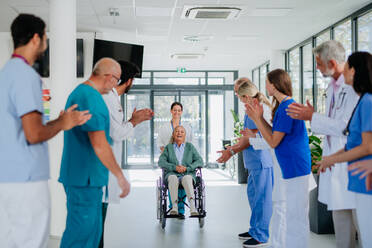 Medizinisches Personal applaudiert einem Patienten, der sich von einer schweren Krankheit erholt hat. - HPIF10003