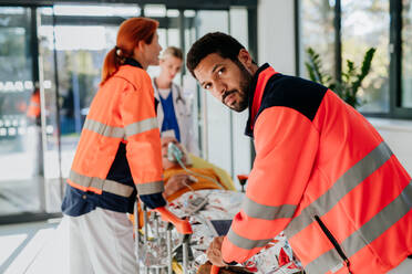 Rettungskräfte versorgen einen Patienten aus einem Krankenwagen. - HPIF10026