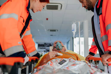 Rettungskräfte versorgen einen Patienten aus einem Krankenwagen. - HPIF10029