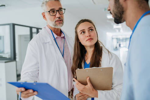 Medizinisches Personal bespricht etwas auf einem Krankenhausflur. - HPIF10043