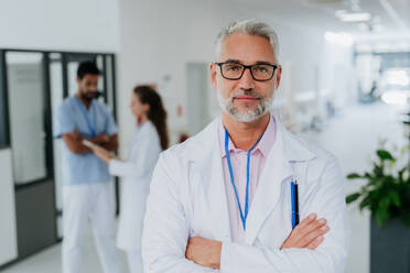 Porträt eines reifen Arztes in einem Krankenhauskorridor. - HPIF10046