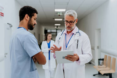 Ärzte besprechen etwas auf einem Krankenhausflur. - HPIF10047
