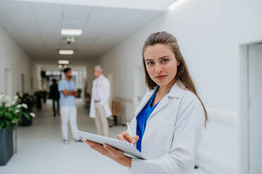 Porträt einer jungen Ärztin in einem Krankenhauskorridor. - HPIF10052