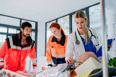 Junge Ärztin, die sich um einen Patienten aus einem Rettungswagen kümmert. - HPIF10072