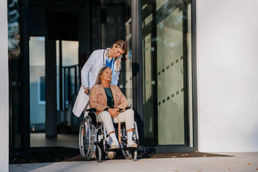 Young woman doctor taking care of senior woman at a wheelchair. - HPIF10086