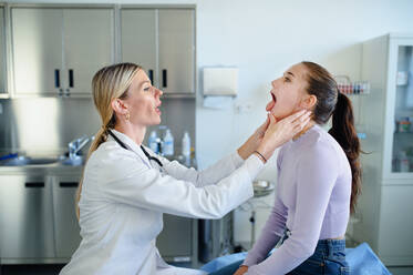 Young woman doctor examining teenage girl in the ambulance. - HPIF10091