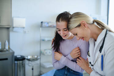Junge Ärztin lächelt mit Teenager-Mädchen im Krankenwagen. - HPIF10104