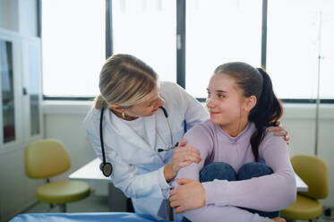Nahaufnahme eines Arztes, der ein junges Mädchen in der Ambulanz tröstet. - HPIF10116