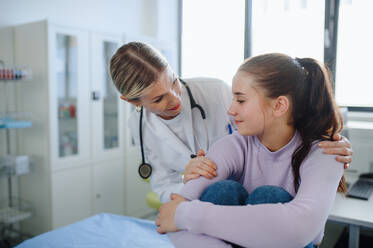 Close-up of doctor consoling teenage girl in the ambulance office. - HPIF10117