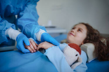 Nahaufnahme eines Arztes, der sich um ein kleines Mädchen in einer Krankenhausabteilung kümmert. - HPIF10227