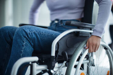 Nahaufnahme einer jungen Frau am Rollstuhl in einem Krankenhaus. - HPIF10238