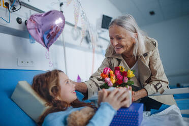 Granmother visiting her sick granddaughter in a hospital, celebrating her birthday. - HPIF10239