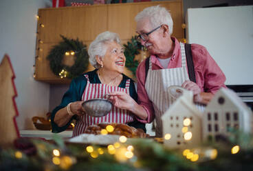 Glückliche Senioren, die zu Hause gemeinsam Weihnachtsgebäck backen. - HPIF10450