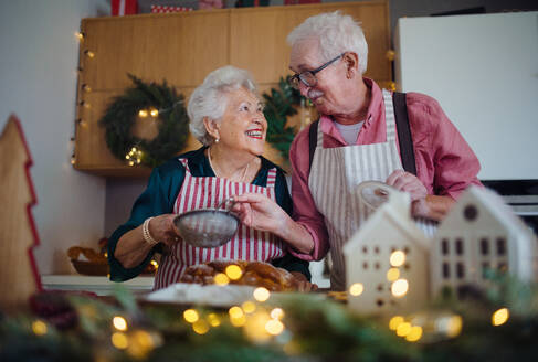 Happy seniors baking Christmas cakes together at home. - HPIF10450