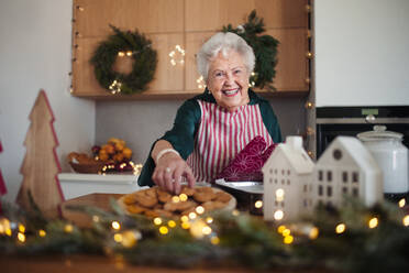 Glückliche Seniorin beim Backen von Weihnachtsgebäck. - HPIF10454