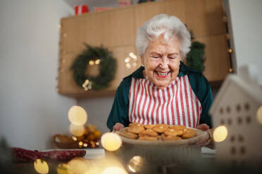 Glückliche Seniorin beim Backen von Weihnachtsgebäck. - HPIF10456